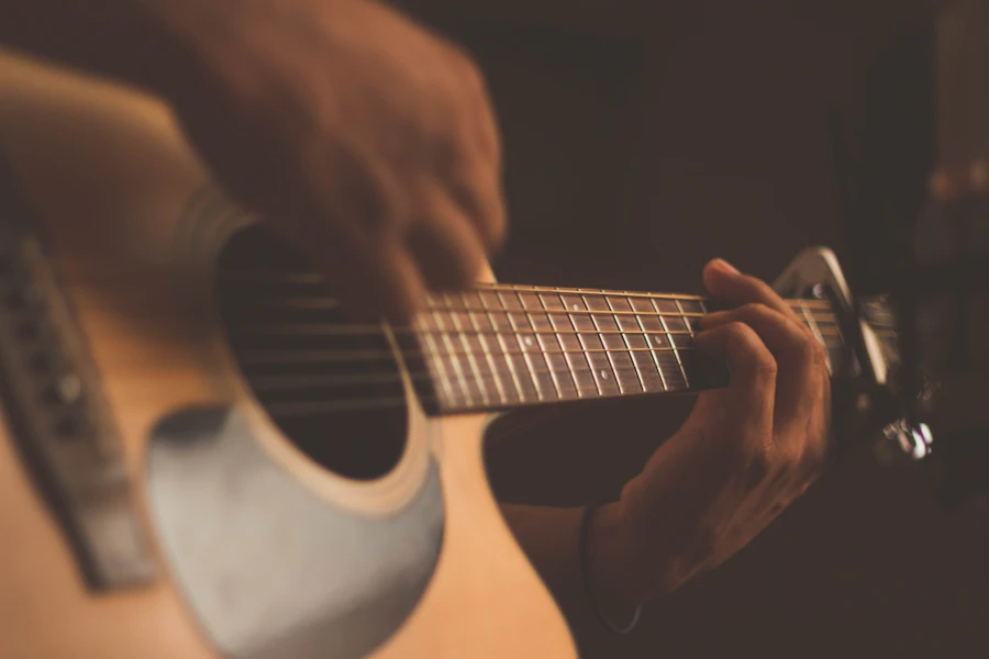 Músico tocando violão, fotografia ilustrativa.